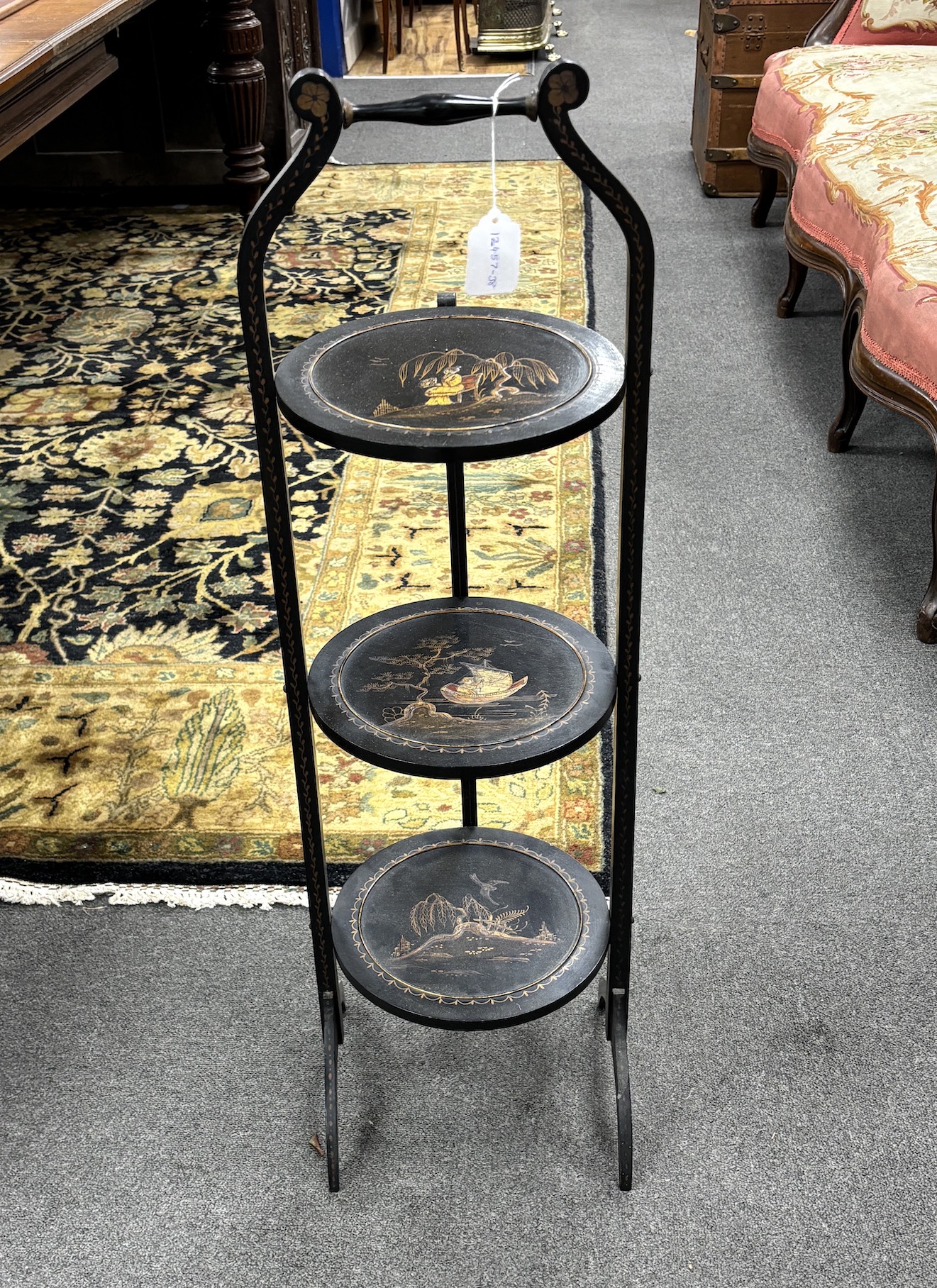 An early 20th century chinoiserie lacquered three tier folding cake stand, height 90cm